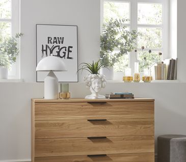 Sideboard aus Massivholz mit einer Front in Beton-Optik hinter einem Couchtisch