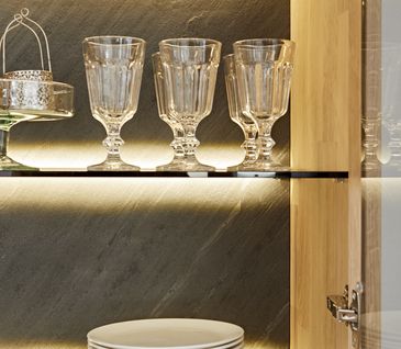 Teller und Gläser auf gläsernen Einlegeböden in einer Vitrine