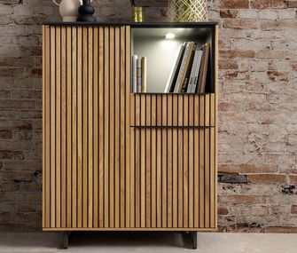 Holz-Kommode dekoriert mit Vasen, Tulpen, und Büchern vor Backsteinwand.