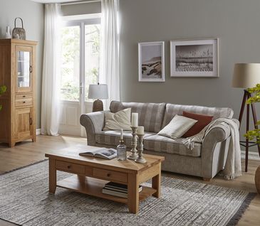 Couchtisch im Landhaus-Stil mit einem Einlegeboden dekoriert mit drei Kerzenständern