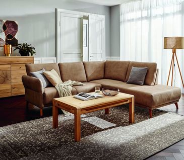Braunes Ecksofa mit Couchtisch und Sideboard aus Massivholz.