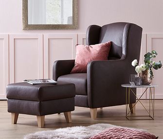 Ledersessel mit naturbelassenen Holzfüßen sorgen ländliche Leichtigkeit Ohrensessel aus Leder mit dem passenden Hocker neben einem zierlichen Beistelltisch