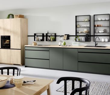 Küche im natürlichen Skandi-Look in Dunkelgrün und hellen Holzelementen.