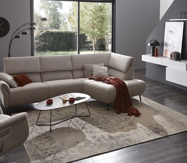 Hellgraues Ecksofa mit besonderem Design.