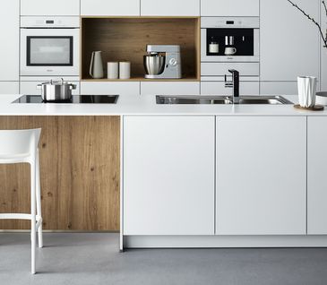 Puristische Inselküche in weiß mit Holzakzenten