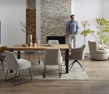 Modern eingerichtetes Esszimmer mit beigen Stühlen mit Stoffbezug und großem Esstisch.