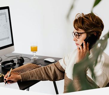 Frau berät am Telefon einen Kunden zur Küchenplanung.