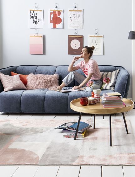 Modernes blaues Sofa mit passendem Hocker mit rundem Beistelltisch.
