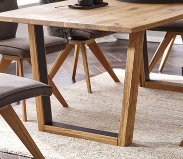 Massivholztisch mit passenden Lederstühlen in rustikalem Esszimmer.