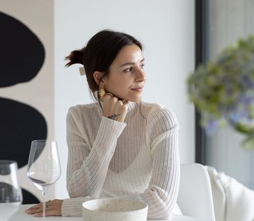 Susanna Wurz in beigem Oberteil sitzt an weißem Esstisch.