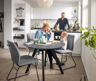 Mutter und Tochter sitzen zusammen an einem runden Esstisch.