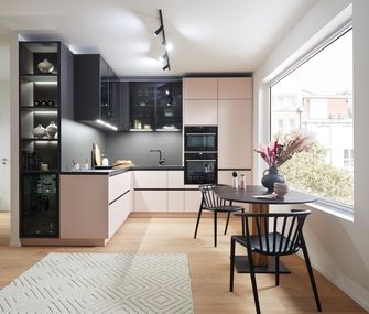 Schwarze Eckküche mit Farbakzenten in Rosa.