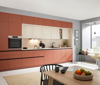 Küchenzeile in der Farbe Terrakotta mit Essbereich.