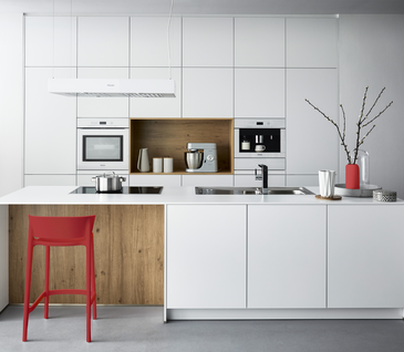 Sie möchten den cleanen Look Ihrer Küche etwas aufpeppen? Dann greifen Sie zu roten Accessoires. Weiße Inselküche mir roten Akzenten.