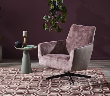 Rosa Samtsessel auf Teppich mit geometrischem Muster vor beerenroter Wand