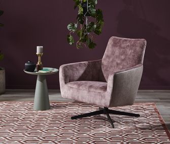 Rosa Sessel vor beerenroter Wand mit Beistelltisch und Pflanze