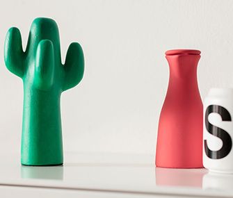 Auch die Dekoration kann an den Skandi-Stil angepasst werden. Ein grüner Deko-Kaktus mit einer roten Vase und einer Tasse mit aufgedrucktem „S“