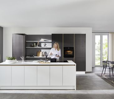 Inselküche mit dunkelbrauner Küchenzeile und weißer Kücheninsel.