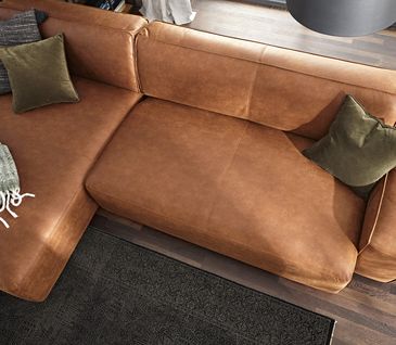 Coganfarbenes Ecksofa mit Kissen.