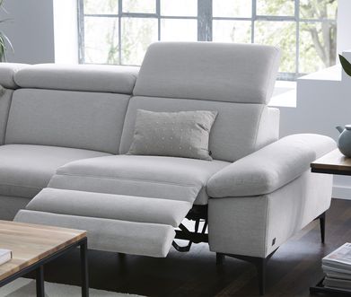 Modernes Sofa in hellgrauem Stoff mit ausklappbarem Fußteil.