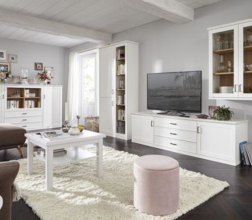 Wohnzimmer im Landhausstil mit weißen Möbeln wie Highboard, Lowboard und Couchtisch