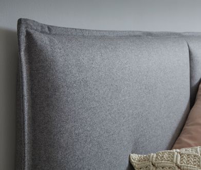 Gepolstertes Bett-Kopfteil mit hellgrauem Stoffüberzug