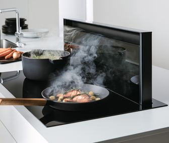 durchdachte E-Geräte erleichtern dir den Alltag in der Küche Ausfahrbarer Dinstabzug neben Kochfeld in weißer Kücheninsel