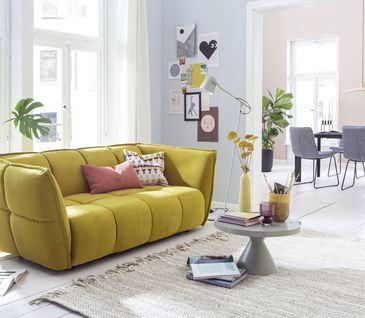 Gelbes Sofa in urbanem Wohnzimmer.