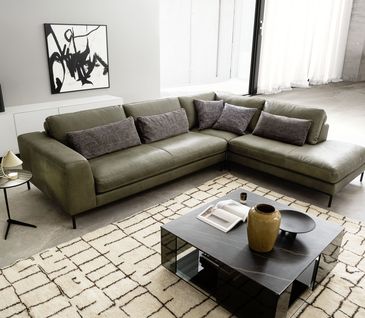 Grünes Ledersofa mir Marmor-Couchtisch und weißem Sideboard in modern-eleganter Umgebung.