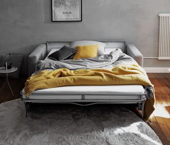 Graues, hochwertiges Schlafsofas aus Stoff als Gästebett mit schöner Bettwäsche vorbereitet