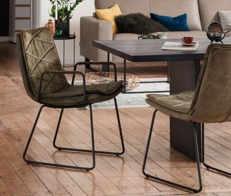 Grüne Stühle am schwarzen Esstisch mit schwarzem Fussgestell