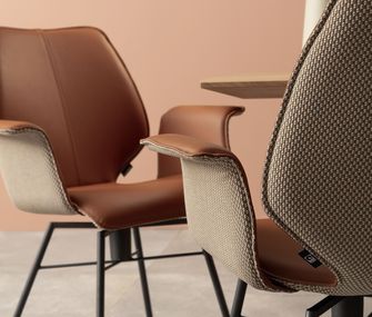 Edler Armlehnstuhl in Rostbraun mit schwarzem Gestell.