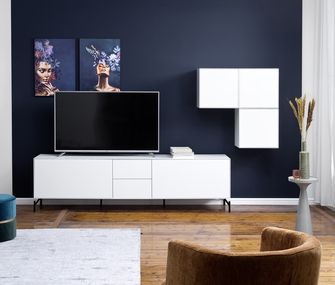 Weiße moderne Wohnwand mit Lowboard und Hängevitrine im Skandi-Stil vor einer dunkelblauen Wand