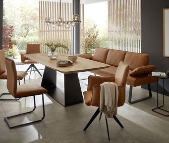 Modernes Esszimmer mit großem Esstisch aus Holz und Metall, Sitzbank und Stühle in cognacfarbenem Leder.