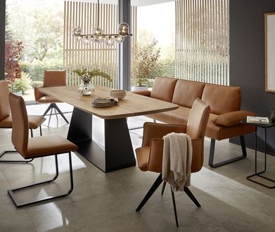 Modernes Esszimmer mit großem Esstisch aus Eiche und Esszimmerstühlen mit Bank in Leder.