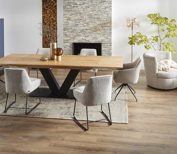 Modernes Esszimmer mit Holztisch, beigen Stühlen, Sessel und blauem Highboard.