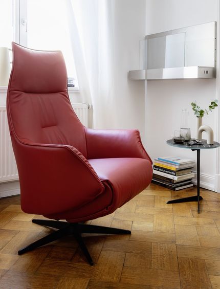 Roter Ledersessel in hellem Altbau-Ambiente.