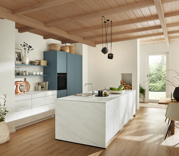 Inselküche in Weiß und Blau mit Marmoroptik.