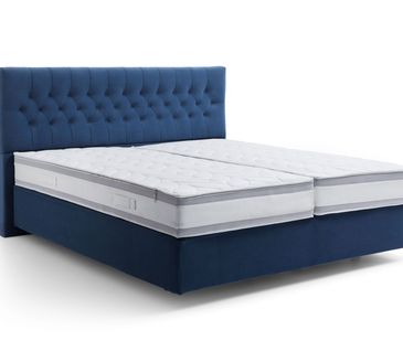 Freisteller eines dunkelblauen Boxspringbettes mit amerikanischen Aufbau ohne Topper