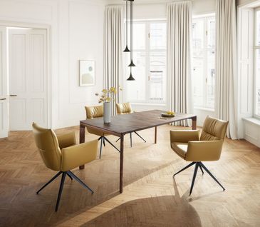 Minimalistisches, elegantes Esszimmer mit großem Esstisch aus Nussbaumholz und Armlehnstühlen in Senfgelb.
