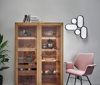 Holz-Vitrine und rosa Armlehnstuhl