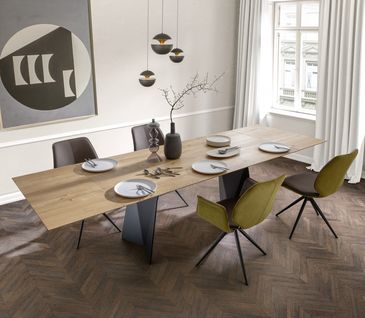 Modernes Esszimmer mit hochwertigen großen Eichentisch und Drehstühlen.