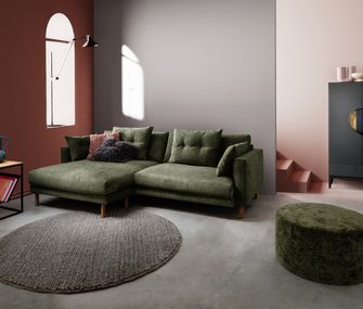 Modernes, minimalistisches Wohnzimmer mit grünem Ecksofa, passendem Hocker, Beistelltisch und schwarzem Highboard.