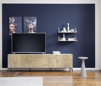 Lowboard mit heller Holzfront und weißen Regalen vor einer satten dunkelblauen Wandfarbe