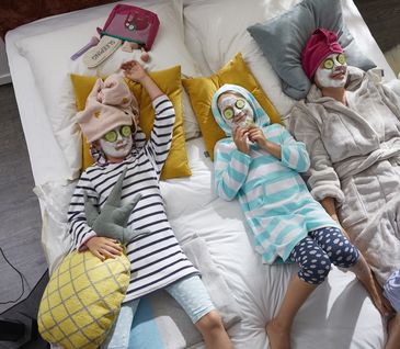 Mutter mit zwei Kindern liegen im Bett und entspannen sich.