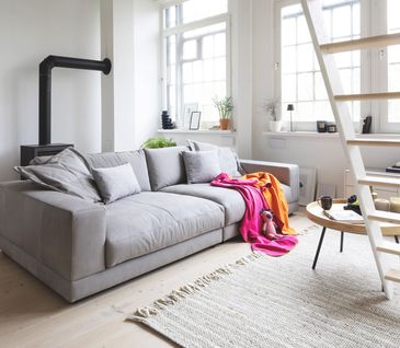 Hellgraues Sofa in heller Loft-Wohnung.