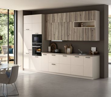 Moderne Küchenzeile in Muschelweiß und Hängeschränken in Holzoptik.