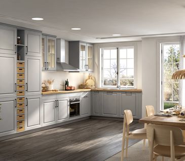 Moderne Landhausküche in L-Form in der Farbe Steingrau und gemütlichem Essbereich.