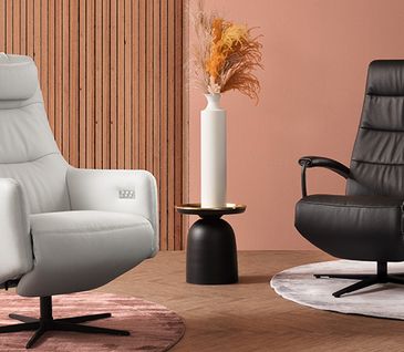 Ein weißer und ein schwarzer Relaxsessel aus Leder und eine Vase in der Mitte