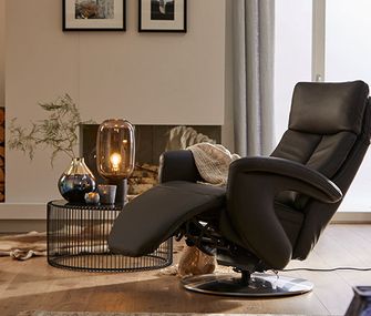 Relaxsessel aus Leder neben einem modernen Beistelltisch mit einer Lampe